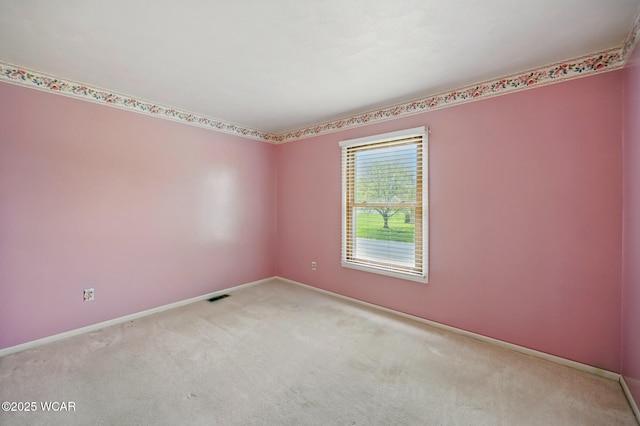 empty room featuring carpet floors, baseboards, and visible vents