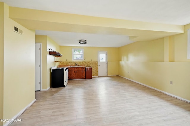 kitchen featuring a sink, light wood finished floors, white range with electric cooktop, baseboards, and visible vents
