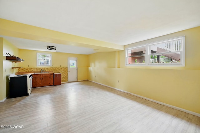 interior space featuring baseboards, a sink, and light wood-style flooring