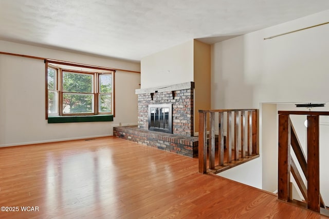 unfurnished living room with wood finished floors and a fireplace