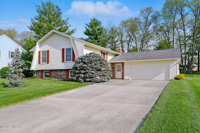 tri-level home with a garage, a front yard, a chimney, brick siding, and concrete driveway