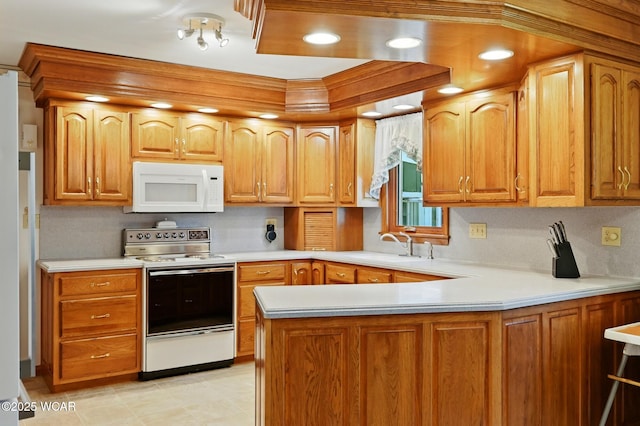 1317 Melrose St, Lima, OH 45801 - kitchen featuring white appliances, light countertops, a peninsula, and brown cabinets