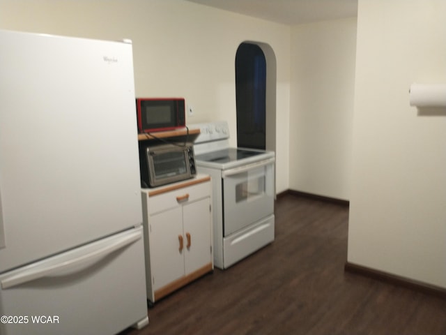 kitchen featuring white appliances, a toaster, baseboards, white cabinets, and dark wood-style floors