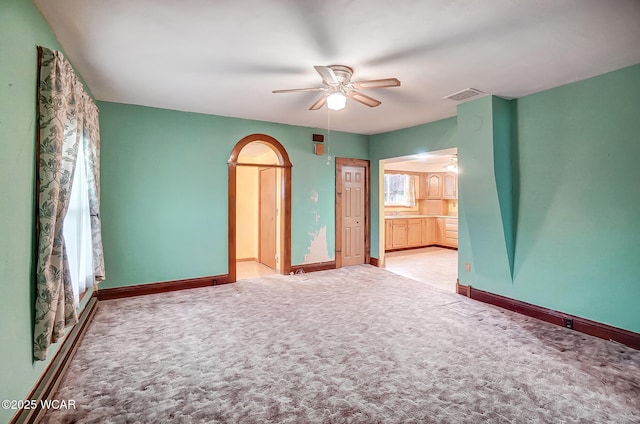 carpeted spare room with baseboards, visible vents, and ceiling fan