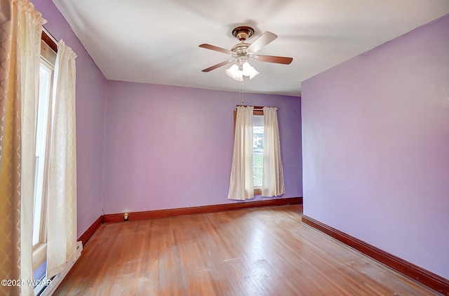 empty room featuring baseboards, ceiling fan, and wood finished floors