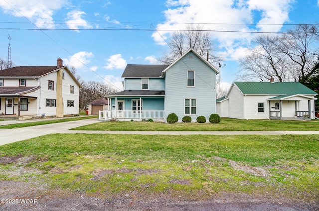 traditional-style house with a front yard, an outbuilding, and a porch