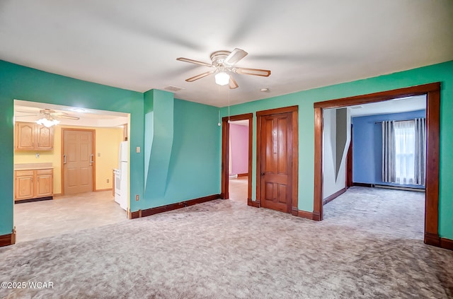 unfurnished bedroom featuring baseboards, ceiling fan, visible vents, and light colored carpet