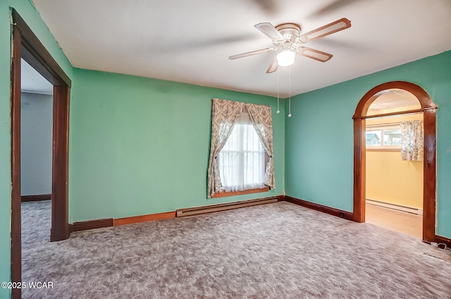 empty room featuring plenty of natural light, baseboard heating, and carpet floors