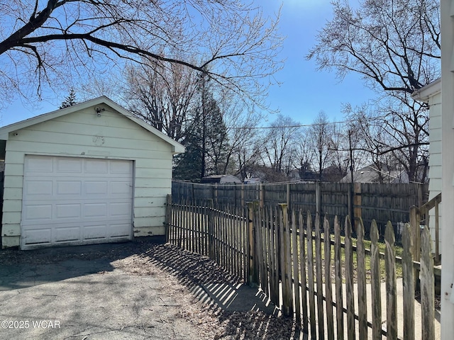 view of yard with an outdoor structure, fence, a garage, and driveway