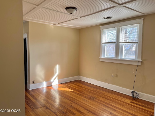 spare room featuring visible vents, wood ceiling, baseboards, and hardwood / wood-style floors