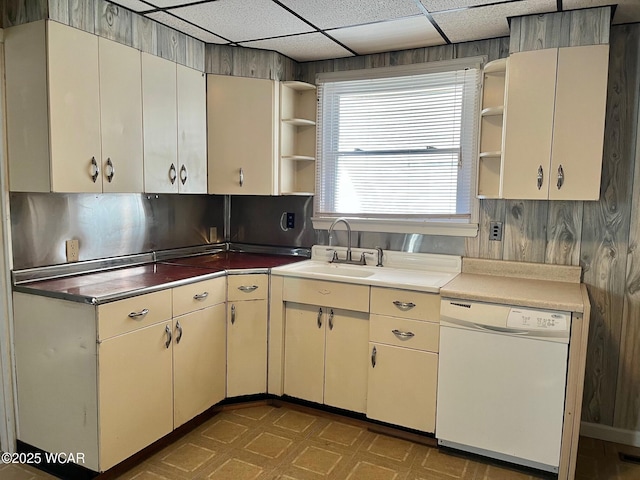 kitchen with open shelves, a drop ceiling, white dishwasher, tile patterned floors, and a sink