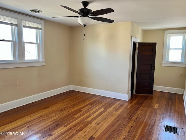 spare room with visible vents, baseboards, ceiling fan, and hardwood / wood-style flooring