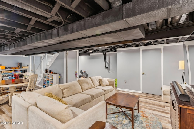 finished below grade area featuring stairs and wood finished floors