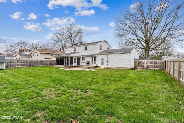 back of house featuring a yard, a fenced backyard, and a sunroom