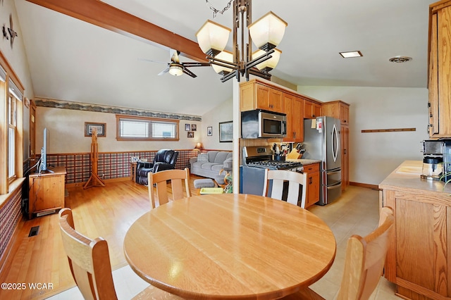 216 N Rauthland Ave, Wapakoneta, OH 45895 - dining area with vaulted ceiling, a ceiling fan, light wood-type flooring, and a wainscoted wall