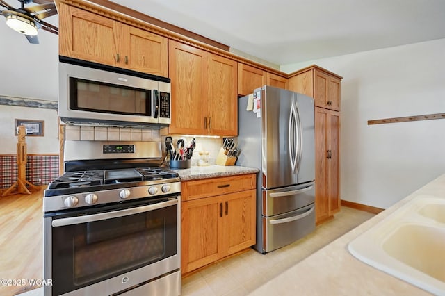 216 N Rauthland Ave, Wapakoneta, OH 45895 - kitchen with stainless steel appliances, brown cabinetry, a sink, and tasteful backsplash