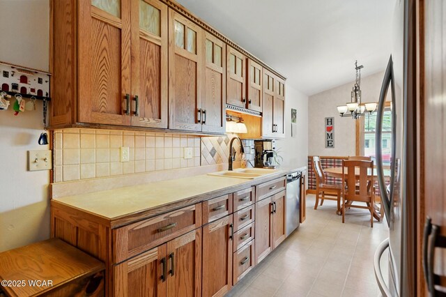 216 N Rauthland Ave, Wapakoneta, OH 45895 - kitchen featuring appliances with stainless steel finishes, a sink, backsplash, light countertops, and vaulted ceiling