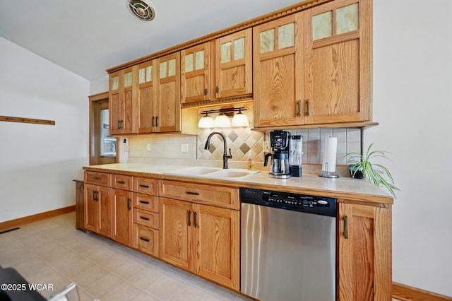 216 N Rauthland Ave, Wapakoneta, OH 45895 - kitchen featuring stainless steel dishwasher, a sink, decorative backsplash, light countertops, and baseboards