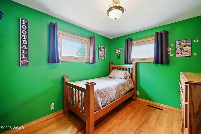 216 N Rauthland Ave, Wapakoneta, OH 45895 - bedroom featuring multiple windows, wood finished floors, and baseboards