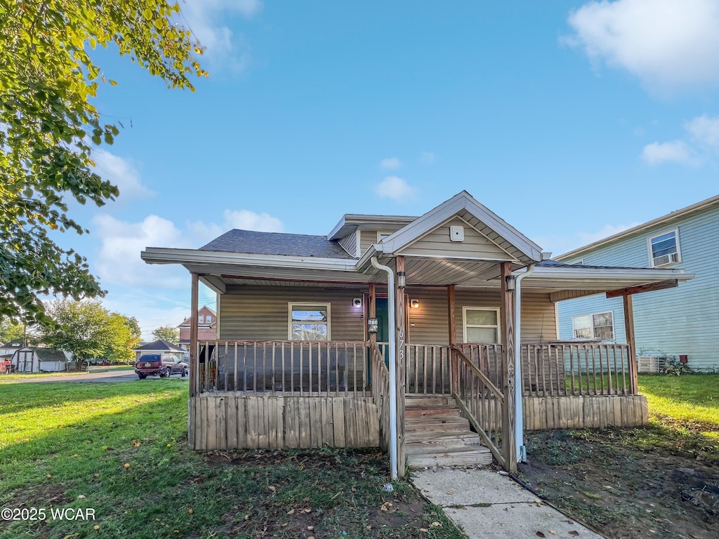 bungalow featuring covered porch and a front lawn