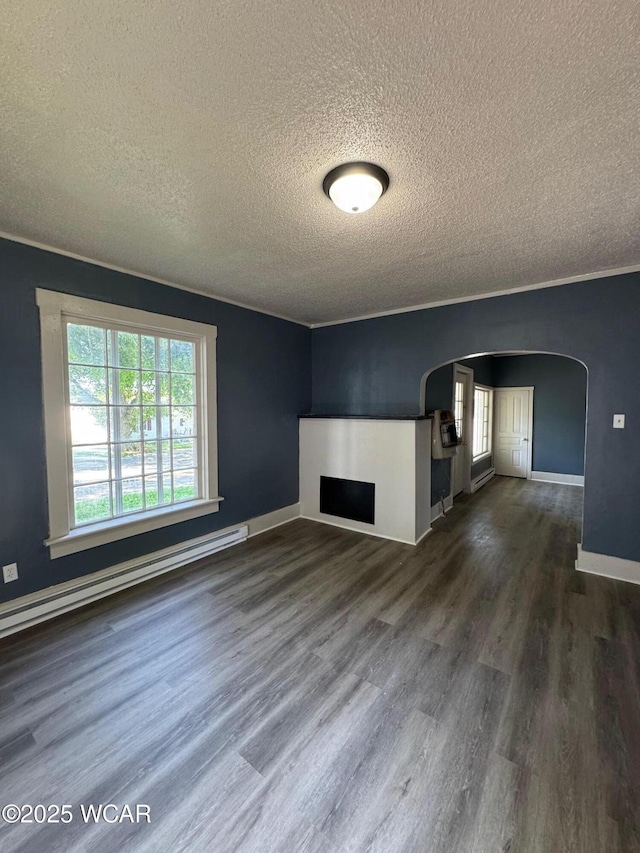 809 King St, Kenton, OH 43326 - unfurnished living room with a textured ceiling, arched walkways, dark wood-type flooring, a fireplace, and baseboard heating