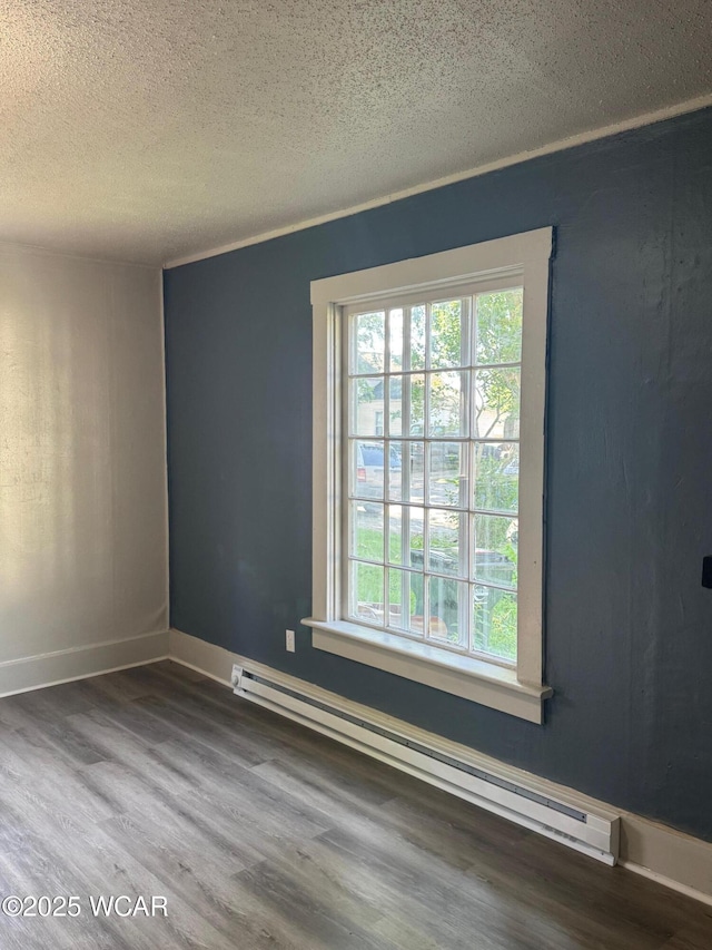 809 King St, Kenton, OH 43326 - unfurnished room featuring a baseboard heating unit, a textured ceiling, plenty of natural light, and wood finished floors