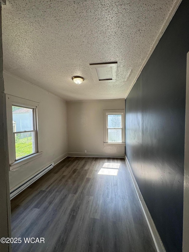 809 King St, Kenton, OH 43326 - unfurnished room with baseboard heating, a textured ceiling, wood finished floors, and attic access