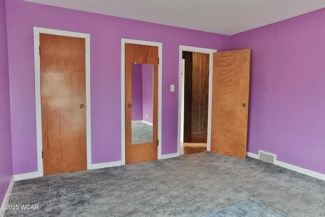 unfurnished bedroom featuring carpet, visible vents, and baseboards