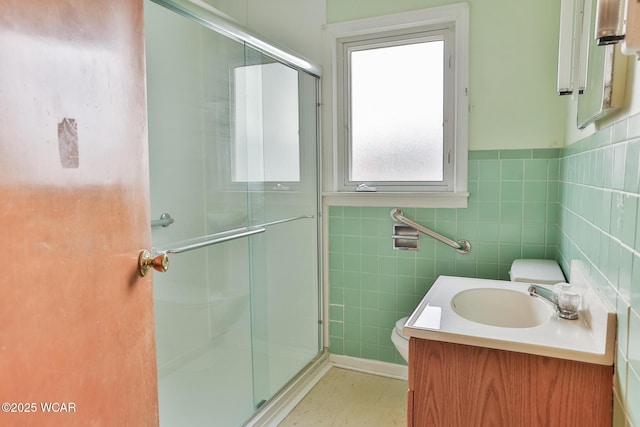 full bathroom featuring vanity, a shower stall, toilet, and tile walls