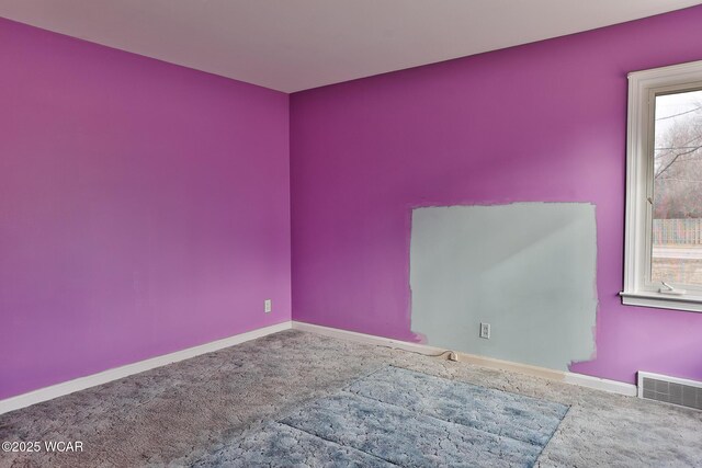 carpeted empty room featuring visible vents and baseboards