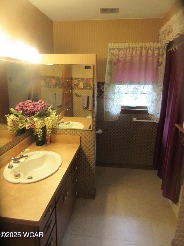 bathroom featuring tile patterned floors, visible vents, vanity, and wallpapered walls