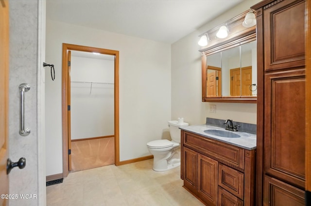 bathroom featuring baseboards, vanity, and toilet