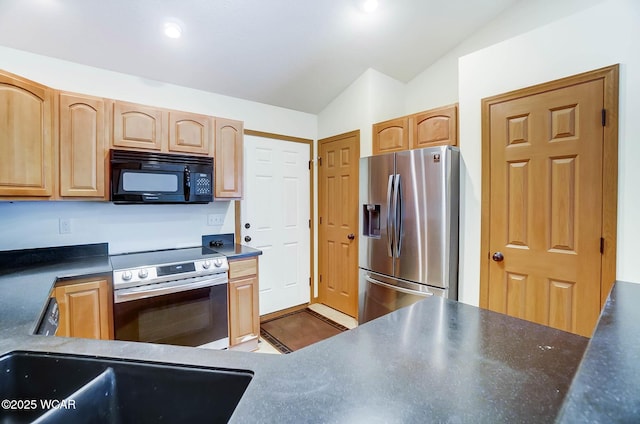 kitchen with lofted ceiling, stainless steel appliances, light brown cabinets, and dark countertops