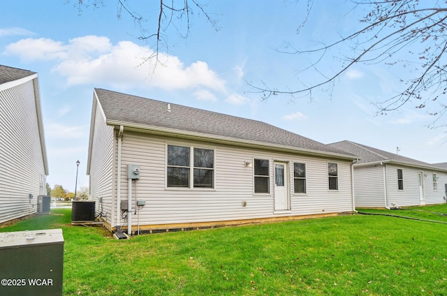rear view of property with a yard and central AC unit