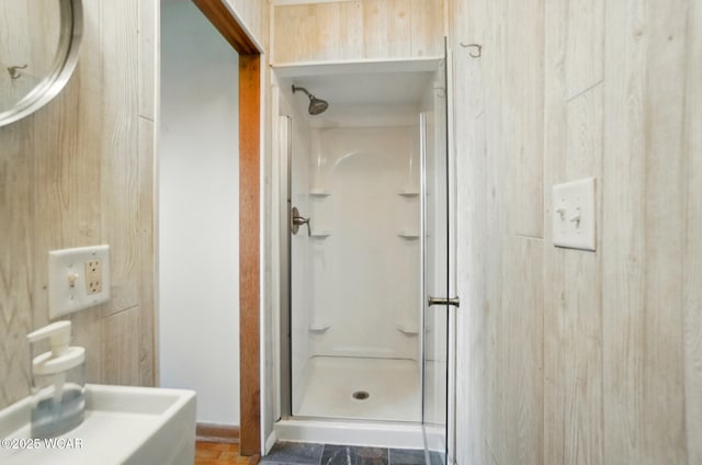full bathroom with a shower stall and wooden walls