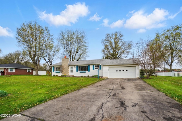 view of front of home featuring a front yard, a garage, a chimney, aphalt driveway, and fence