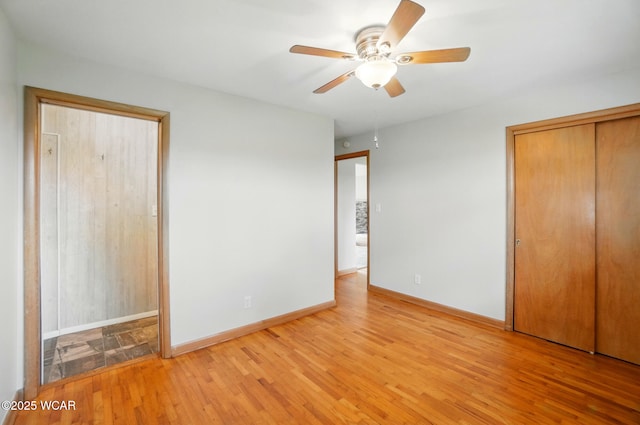 unfurnished bedroom featuring ceiling fan, light wood finished floors, and baseboards