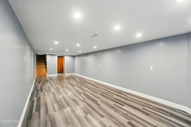 finished below grade area with recessed lighting, visible vents, light wood-style floors, and baseboards