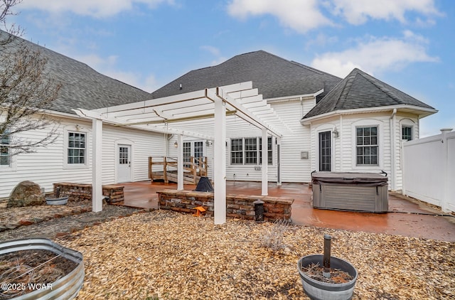 back of property featuring a hot tub, a shingled roof, fence, a patio area, and a pergola