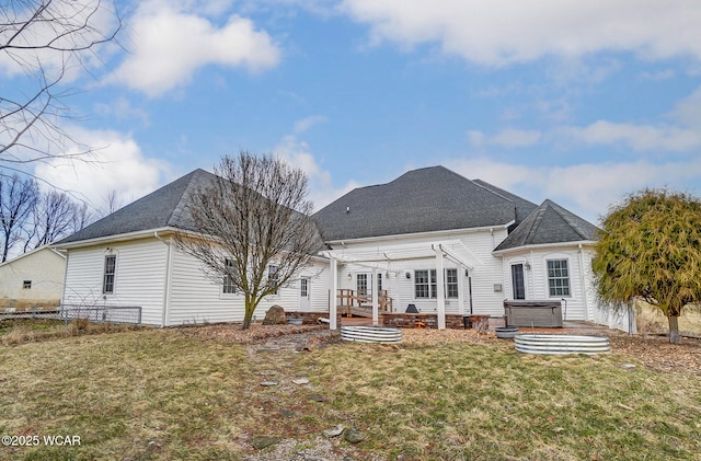 rear view of house with a yard, a hot tub, fence, a pergola, and a wooden deck