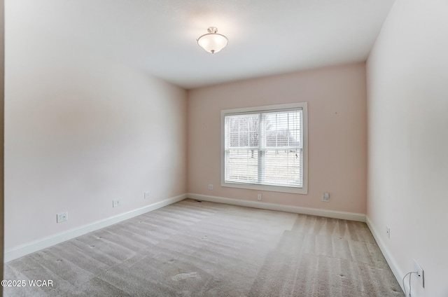 carpeted empty room featuring baseboards