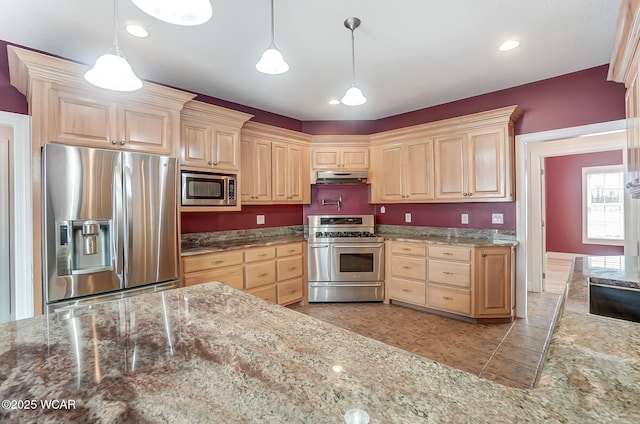 kitchen with hanging light fixtures, stone counters, stainless steel appliances, light brown cabinetry, and under cabinet range hood