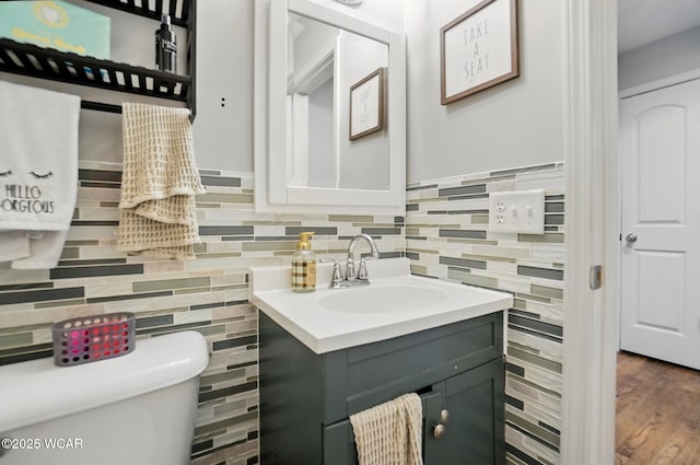 1826 W High St, Lima, OH 45805 - bathroom with vanity, toilet, tile walls, and wood finished floors
