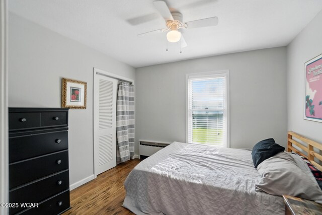 1826 W High St, Lima, OH 45805 - bedroom featuring wood finished floors, a baseboard radiator, a ceiling fan, and a closet