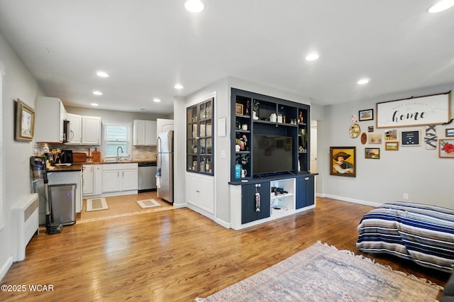 1826 W High St, Lima, OH 45805 - living area with recessed lighting, light wood-style flooring, baseboards, and radiator heating unit