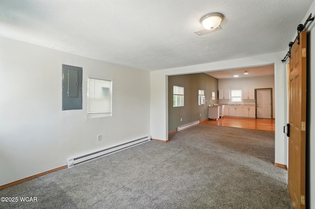 1151 S Central Ave, Lima, OH 45804 - unfurnished living room featuring a baseboard heating unit, a barn door, electric panel, carpet flooring, and a textured ceiling