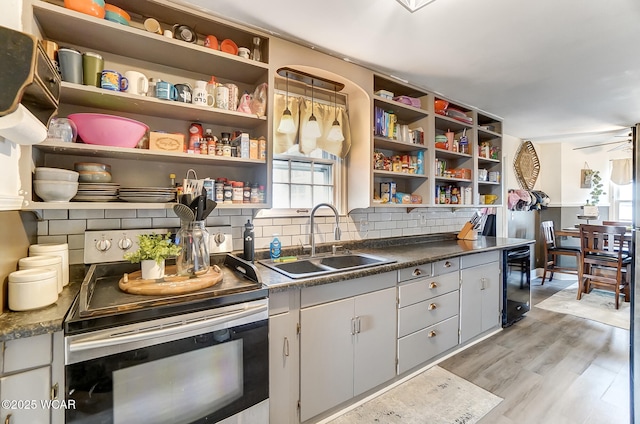 kitchen featuring wine cooler, sink, tasteful backsplash, electric stove, and light hardwood / wood-style floors