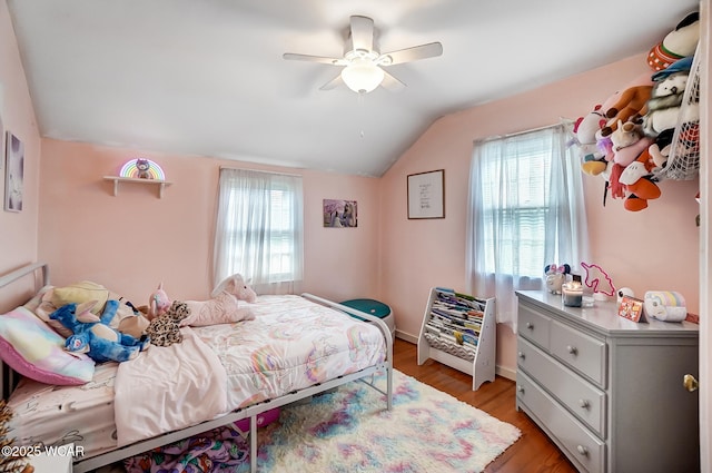 bedroom with multiple windows, ceiling fan, lofted ceiling, and light wood-type flooring