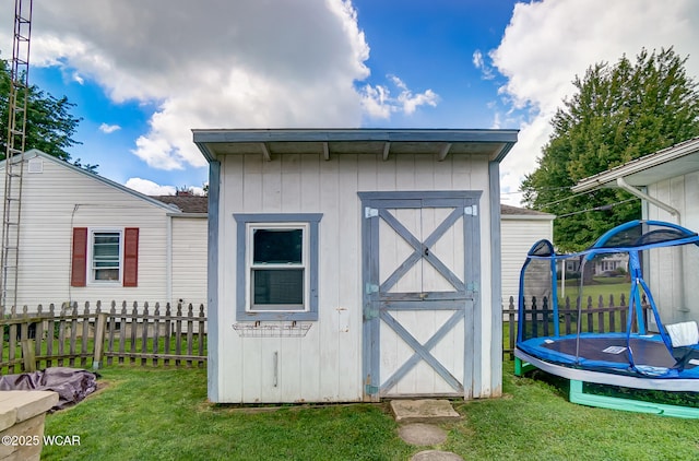 view of outbuilding with a yard and a trampoline