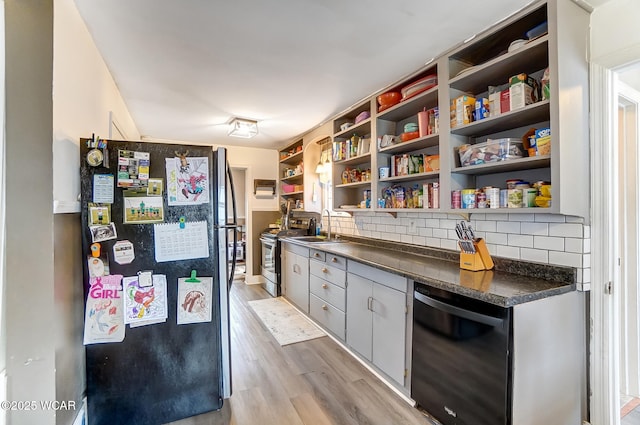 kitchen with sink, decorative backsplash, stainless steel appliances, and light hardwood / wood-style floors